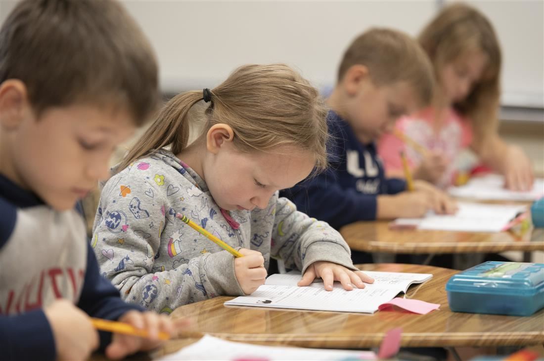Students in class writing in journals